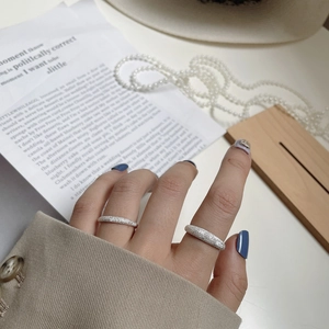Close-up of S925 sterling silver rings with sparkling sand texture worn by a model