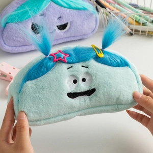 Close-up of cute plush cartoon pencil cases with embroidered faces and colorful fur