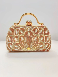 Detail of orange evening bag with white pearls, rhinestones and golden metal handle