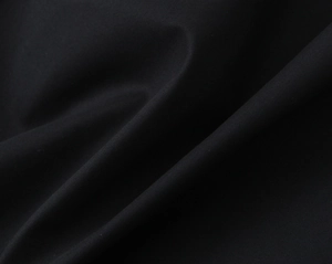Close-up detail of high-quality black textile fabric texture and woven twill pattern