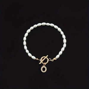 Elegant white oval pearl bracelet with a golden T-bar clasp and rhinestone letter O charm