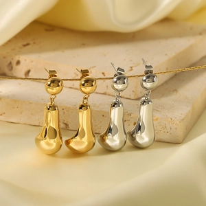 Polished 18K gold and silver chunky teardrop earrings on elegant silk background