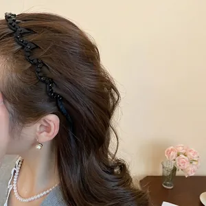 Elegant wavy black beaded headband worn by model with minimalist jewelry and soft background