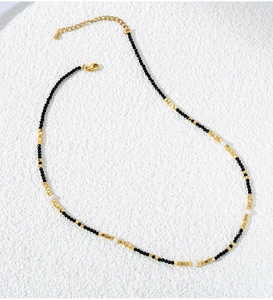 Detail of beaded necklace featuring black spinel, gold cubes, and small pearls with clasp