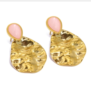 Detail of pink teardrop stone set on hammered gold stainless steel stud earrings