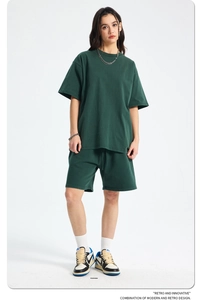 Detail of high-weight washed cotton fabric on green oversized T-shirt and shorts set