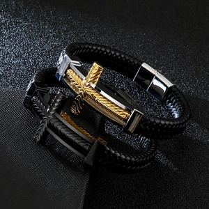 Macro detail of men's braided leather bracelet with embossed cross metal clasp