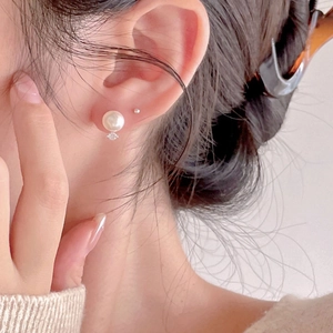 Elegant 925 sterling silver pearl earrings with small zircon stone on a model