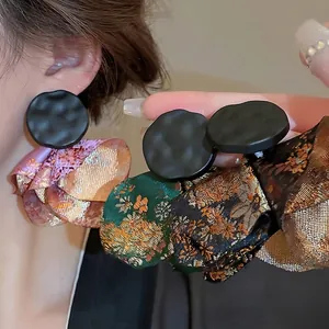 Ethnic Chinese style earrings with black hammered metal disc and floral silk petal tassels