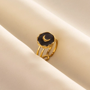 Adjustable golden stainless steel moon ring with black inlay on silk background