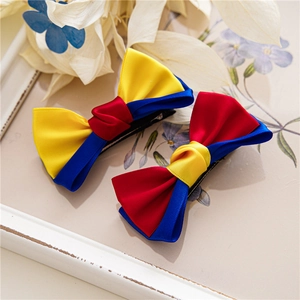 Detail of cute colorful fabric bow hair clips for girls on decorative floral frame