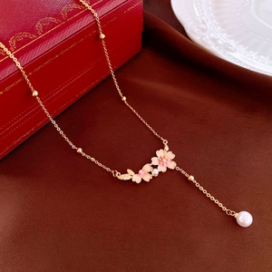 Elegant gold-plated necklace with pink oil-dripped flowers and pearls on fabric