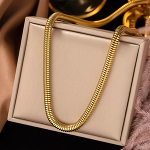 Close-up of golden titanium steel snake bone chain necklace on jewelry display box