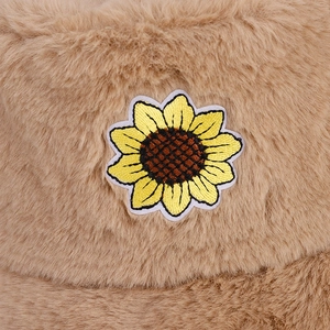 Vista macro del tessuto in peluche kaki con ricamo di girasole sul cappello alla pescatora