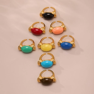 Set of 8 colorful oval resin rings with golden adjustable bands on pink background