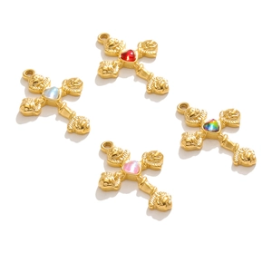 Golden stainless steel cross pendants with colorful heart-shaped gemstones in macro view