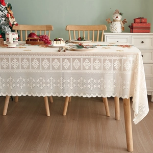 Detailed close-up of beige Christmas lace tablecloth featuring elegant snowflake patterns