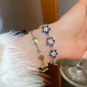 Set of gold shell chain bracelet and blue floral enamel bracelet for elegant women