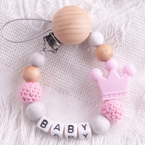 Detail of pink silicone crown bead and wooden clip on baby pacifier chain accessory