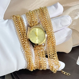 Detailed view of women's gold wrap bracelet watch with quartz movement on silk background
