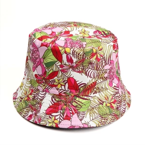 Detail of vibrant floral and palm leaf print on a reversible sun bucket hat fabric