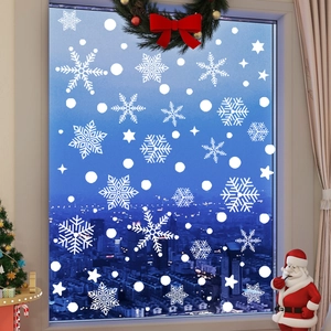 Detail of white snowflake window clings on glass with urban night background scene