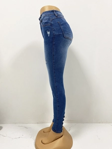 Détails d'un jean skinny taille haute avec genoux déchirés et boutons aux chevilles