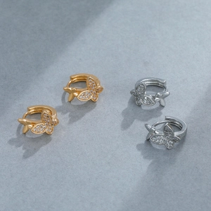 Detailed view of gold and silver butterfly earrings encrusted with sparkling cubic zirconia