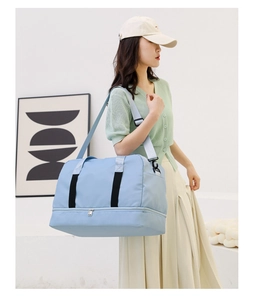 Macro view of light blue travel tote showing separate bottom compartment for shoes