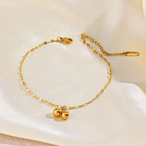 Elegant gold plated stainless steel bead bracelet with adjustable chain on white silk