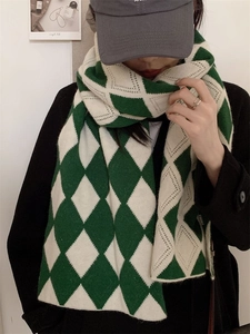 Détail de l'écharpe en maille losange vert et blanc montrant la texture douce et épaisse
