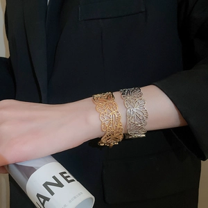 Detail of hollow butterfly cuff bracelets in gold and silver finish on model