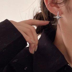 Close-up of 925 sterling silver star stud earring with a central diamond on ear