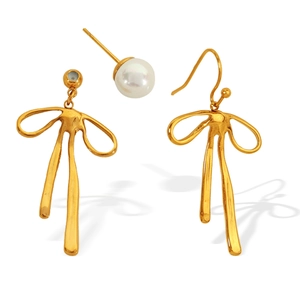 Elegant gold bow earrings with white pearl accents on a minimalist white background