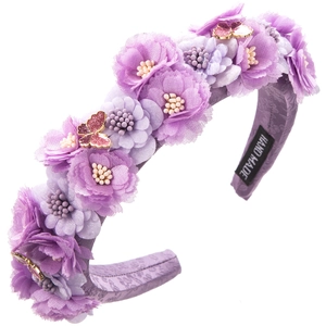 Detailed macro view of handmade purple floral headband with beaded centers and butterfly motifs