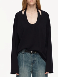 Detail of black layered loose-fit long sleeve top with metal buckle belt and blue jeans