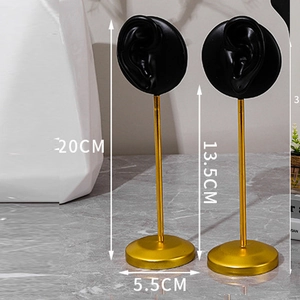 Detail of 20cm gold metal jewelry stand with black resin ear mold for earring display