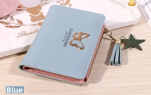 Detail view of small blue bi-fold wallet featuring tassel zipper and star charm pendant