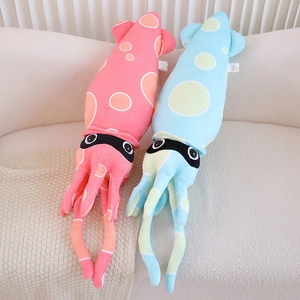 Detail of pink and blue plush squid toys with polka dots on a soft beige fabric sofa