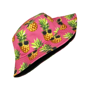Close-up of pink bucket hat featuring pineapple pattern and black interior lining