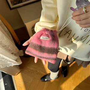 Close-up of pink and brown striped knit drawstring pouch with soft plush texture