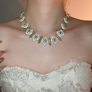 Close-up of vintage diamond heart necklace with gold plating and blue enamel detailing
