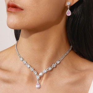 Macro shot of silver-tone necklace set with teardrop pink gemstones on a model