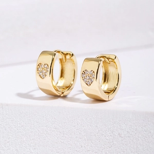 Minimalist wide huggie earrings with gold heart zircons on white platform