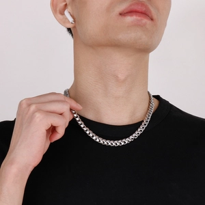 Détail d'une chaîne cubaine en acier inoxydable argenté sur le cou d'un mannequin