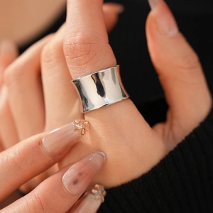 Close-up of minimalist wide band silver ring with polished finish on model finger