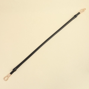 Detail view of a slim black leather belt with elegant gold metal buckles on a neutral base