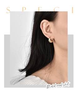 Polished gold chunky hoop earrings displayed on a female model with high mirror finish