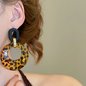 Close-up of vintage leopard print acrylic hoop earrings with stylish matte black studs