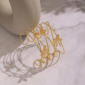 Macro detail of 18K gold-plated open dragonfly cuff with pavé zircon stones